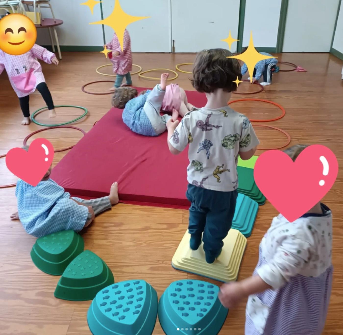 Niños recorriendo los aros y los escalones de texturas sobre la colchoneta roja